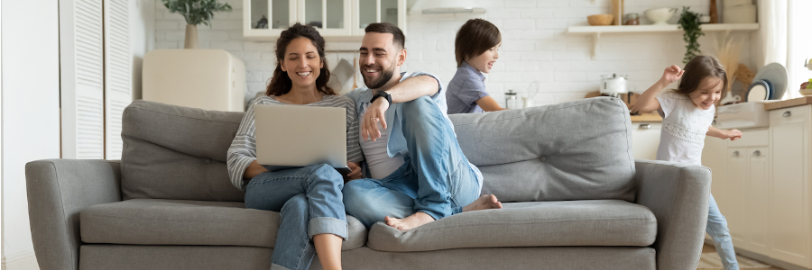 parents on couch using laptop to secure their network to keep hackers out of their home network